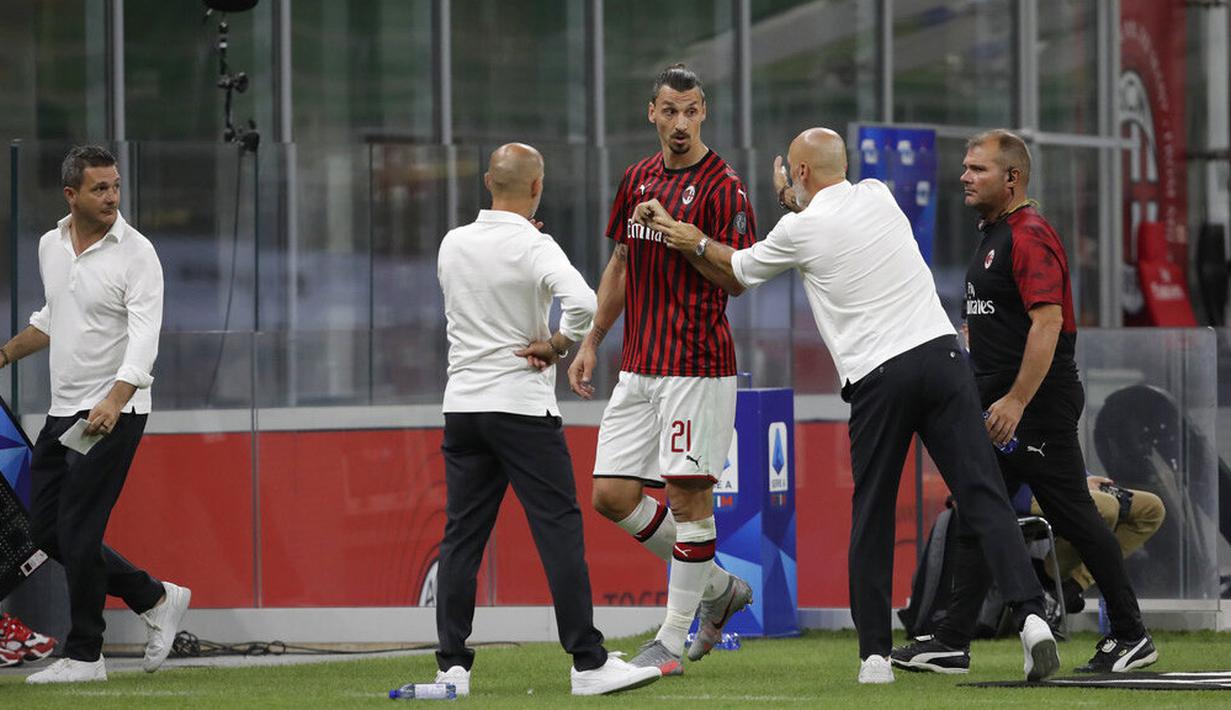 Pelatih AC Milan, Stefano Pioli, berusaha menenangkan Zlatan Ibrahimovic yang kecewa usai diganti saat melawan Bologna pada laga Serie A di Stadion San Siro, Sabtu (18/7/2020). AC Milan menang dengan 5-1 atas Bologna. (AP/Luca Bruno)