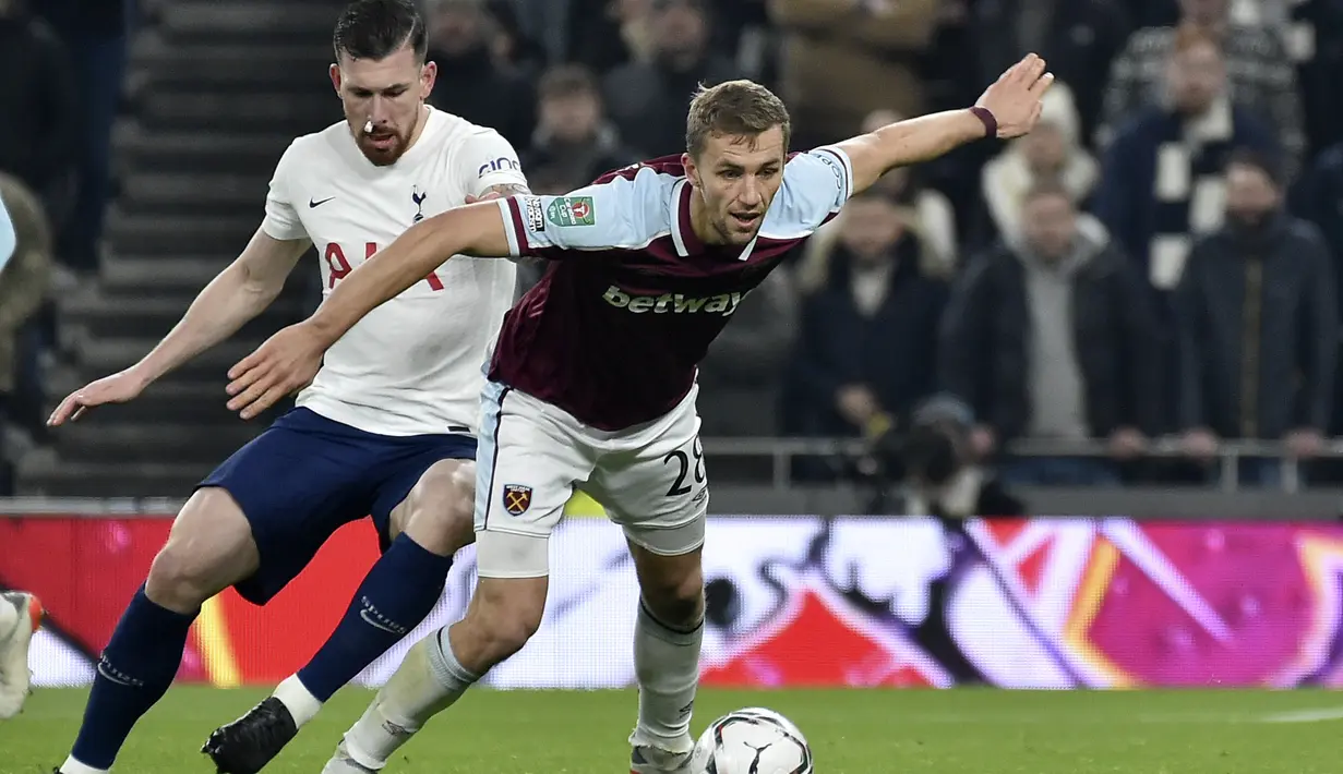 Gelandang West Ham, Tomas Soucek mengontrol bola dari kawalan bek Tottenham, Pierre-Emile Hojbjerg pada pertandingan perempat final Piala Liga Inggris di Stadion Tottenham Hotspur di London, Kamis (23/12/2021). Tottenham menang tipis atas West Ham 2-1. (AP Photo/Rui Vieira)