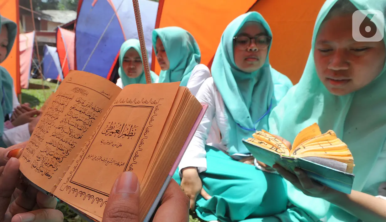 Santri membaca Al-Qur'an saat kegiatan Kemah Hari  Santri di Bogor, Selasa (22/10/2019). Pemerintah menetapkan 22 Oktober sebagai HSN bertepatan dengan Resolusi Jihad yang dikumandangkan  pendiri Nahdlatul Ulama KH. Hasyim Asyari untuk mempertahankan kemerdekaan RI. (merdeka.com/Arie Basuki)