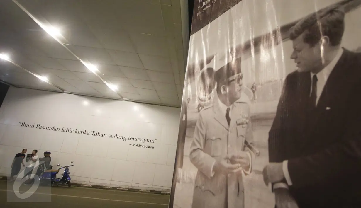 Sejumlah orang berdiri di depan mural bertema Kota Bandung di Jalan Asia Afrika, Bandung, Jawa Barat, Selasa (5/7). Dua buah mural tersebut menjadi lokasi favorit bagi warga dan wisatawan di Bandung untuk berfoto. (Liputan6.com/Immanuel Antonius)