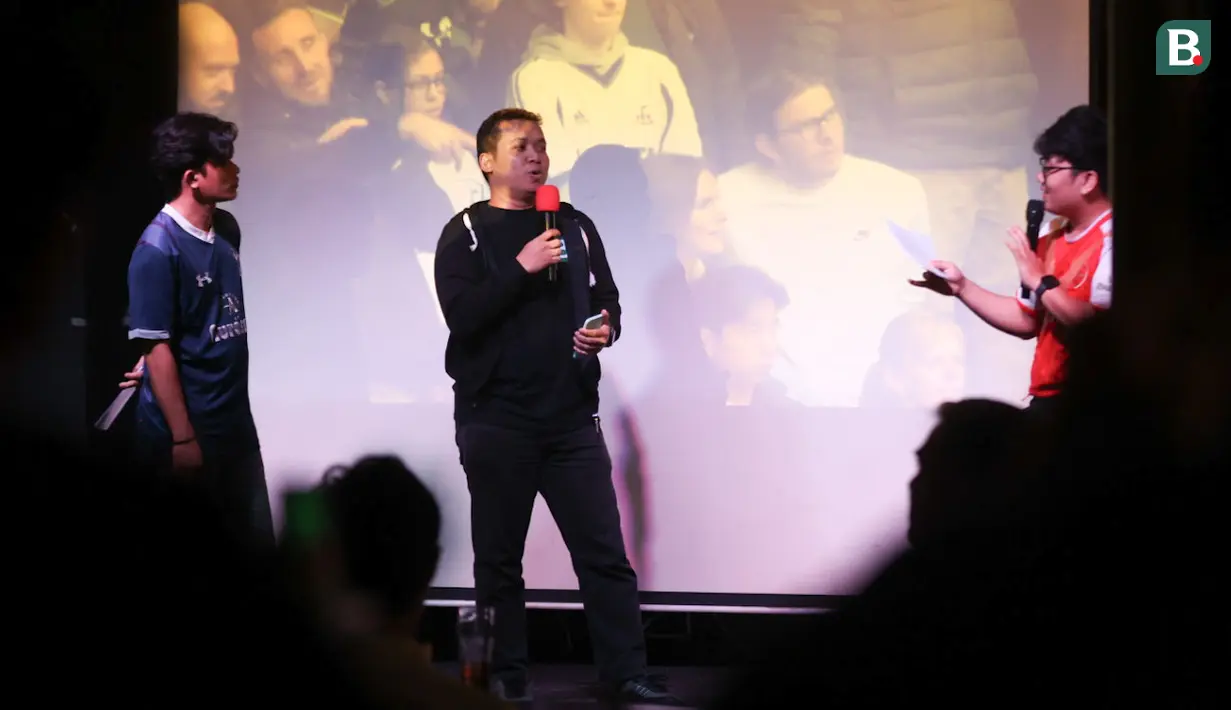 Jurnalis Bola.com, Gerendo Pradigdo (tengah) memberikan prediksinya dalam acara nonton bareng Roaring Night Liga Inggris 2023/2024 antara Tottenham Hotspur kontra Arsenal di Treehaus Kemang, Minggu (28/4/2024) malam WIB yang digelar komunitas penggemar Tottenham Hotspur, IndoSpurs Jakarta. (Bola.com/Abdul Aziz)