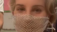 Lana Del Rey mendapat banjir kritikan setelah mengenakan masker jaring di acara penandatanganan buku puisi terbarunya. (Screenshot Instagram @lanadelrey/https://www.instagram.com/p/CF260mXpmbP/)