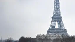 Suasana di dekat Menara Eiffel saat hujan salju di Paris, Prancis (7/2). Ratusan orang terpaksa meninggalkan mobil mereka untuk tidur di tempat penampungan darurat akibat cuaca ekstrem yang melanda. (AFP Photo/Stephane De Sakutin)
