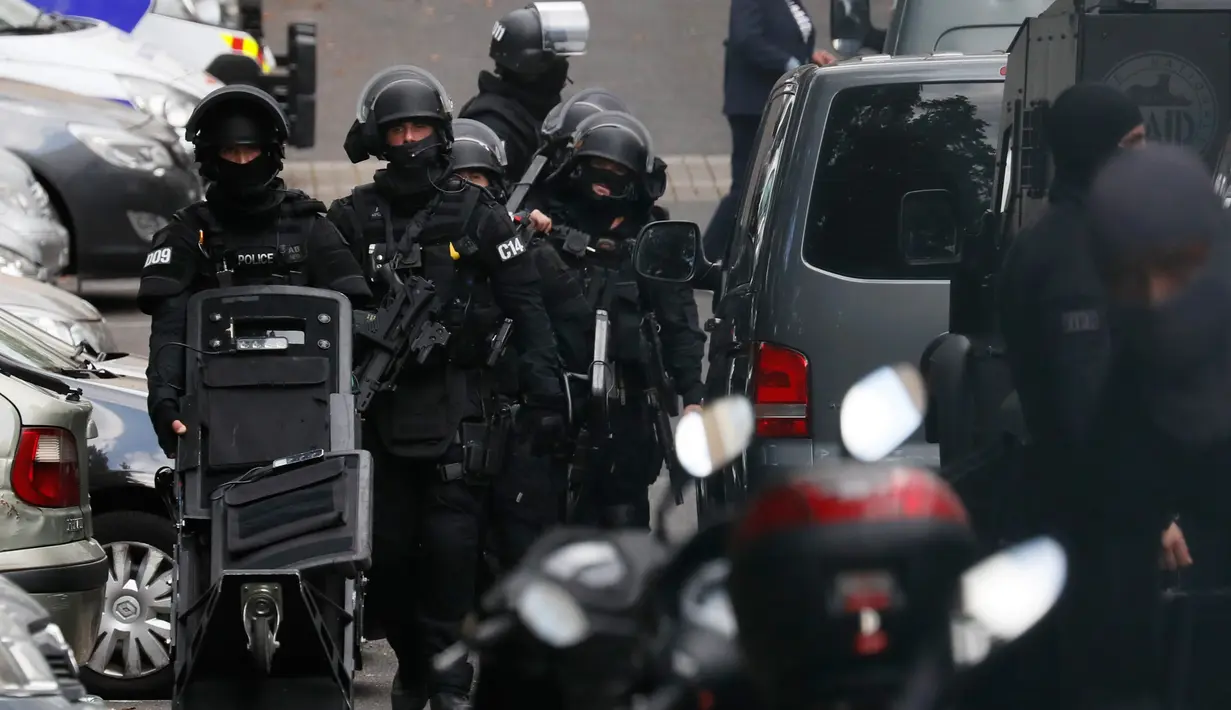 RAID (satuan polisi elit) meninggalkan bangunan tempat tinggal pelaku penembakan di supermarket Kota Port-Marly dekat Paris, Senin (26/9). Polisi menyebut penembakan yang dilakukan pria 60 atau 70-an tahun itu dipicu persoalan pribadi. (Thomas Samson/AFP)