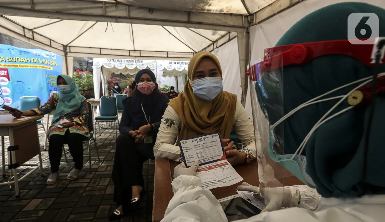 Petugas medis mendata tenaga kesehatan sebelum disuntik vaksin COVID-19 Sinovac di Puskesmas Palmerah, Jakarta, Kamis (28/1/2021). Pemberian vaksin COVID-19 tahap kedua dilaksanakan terhadap tenaga kesehatan mulai hari ini. (Liputan6.com/Johan Tallo)