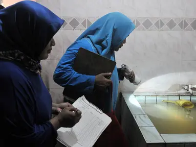 Tim Juru Pemantau Jentik (Jumantik) Kelurahan Duren Sawit melakukan pemantauan jentik nyamuk Aedes Aegypti pada bak mandi salah satu warga di kawasan Duren Sawit, Jakarta, Rabu (27/2). (Merdeka.com/Iqbal S. Nugroho)