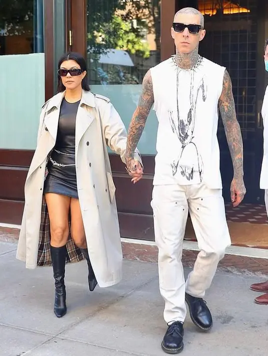 Kali ini keduanya tampil dengan outfit monokrom. Kourtney melengkapi leather dress hitamnya dengan long coat. Sementara Travis mengenakan cutoff grafis t-shirt warna putih  dan sepatu docmart warna hitam. (Instagram/kravis_love).