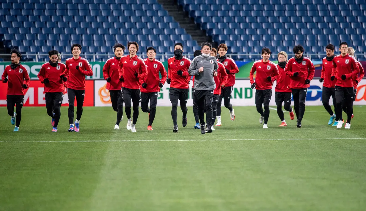 Para pemain Jepang melakukan pemanasan dalam sesi latihan di Stadion Saitama di Saitama (31/1/2022). Jepang akan bertanding melawan Arab Saudi Grup B putaran 3 Kualifikasi Piala Dunia 2022 Zona AFC. (AFP/Philip Fong)