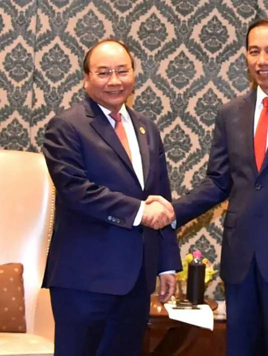 Presiden Joko Widodo dan PM Vietnam, Nguyen Xuan Phuc berjabat tangan usai pertemuan bilateral disela KTT ASEAN-India di New Delhi, Jumat (26/1). Pertemuan membahas peningkatan hubungan kerja sama ekonomi dan maritim. (Liputan6.com/Pool/Biro Pers Setpres)