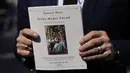 R. Couri Hay, teman lama Ivana Trump, membawa jadwal rangkaian pemakaman Ivana Trump di New York, Rabu (20/7/2022). Tidak ada kamera yang diperbolehkan di dalam gereja selama kebaktian pada rangkaian acara pemakaman Ivana Trump. (AP Photo/John Minchillo)