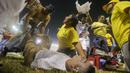 Tim medis dan beberapa sukarelawan tampak memberikan pertolongan kepada seorang korban saat terjadi kerusuhan suporter akibat saling berebut masuk ke dalam Stadion Monumental, Cuscatlan, San Salvador, El Salvador, Sabtu (21/5/2023) waktu setempat untuk menyaksikan laga perempatfinal Divisi Utama El Salvador antara Alianza FC menghadapi Deportivo FAS. (AP Photo/Milton Flores)