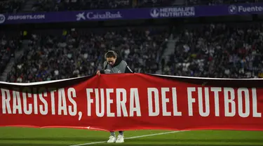 Sebuah spanduk bertuliskan dalam bahasa Spanyol, "Rasis, menjauhlah dari sepak bola" ditampilkan sebelum pertandingan La Liga Spanyol antara Valladolid vs Barcelona di stadion Jose Zorrilla Selasa, 23 Mei 2023. (AP Photo/Manu Fernandez)