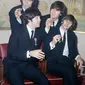 Personil The Beatles George Harrison, Paul McCartney, John Lennon dan Ringo Starr menunjukkan medali yang diberikan Ratu Elizabeth II dalam sebuah upacara di Istana Buckingham di London, Inggris pada 26 Oktober 1965. (AP Photo, File)