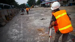 Seorang petugas sedang mengukur tingkat kemiringan tanah yang akan dijadikan pondasi, Jakarta, Rabu (20/8/2014) (Liputan6.com/Faizal Fanani)