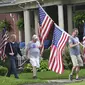 Masyarakat Amerika Serikat (AS) merayakan parade Fourth of July dengan membawa bendera di Westmont, Suburb of Johnstown, Selasa (4/7/2023). (John Rucosky/The Tribune-Democrat via AP)