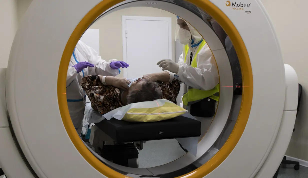 Petugas medis mempersiapkan pasien dengan virus corona untuk pemeriksaan CT scan di aula perawatan rumah sakit sementara COVID-19 di Istana Es Krylatskoye di Moskow, Rabu (10/2/2021). Rusia mencatat lebih dari empat juta kasus infeksi virus Corona atau COVID-19. (AP/Alexander Zemlianichenko)