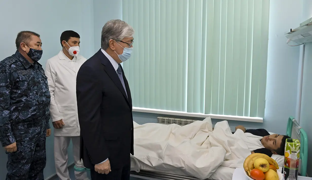 Presiden Kazakhstan Kassym-Jomart Tokayev (tengah) berbicara kepada salah satu yang terluka selama kerusuhan saat ia mengunjungi Departemen Traumatologi rumah sakit di Almaty, Kazakhstan, Rabu (12/1/2022). (Kazakhstan's Presidential Press Service via AP)