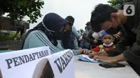 Warga menjalani pendataan saat melakukan vaksinasi booster COVID-19 di Balai RW 04, Ciganjur, Jakarta Selatan, Senin (18/7/2022). Wajib vaksinasi ketiga atau booster COVID-19 untuk perjalanan dan masuk ke ruang publik diberlakuan untuk mengejar cakupan vaksin booster yang hingga saat ini baru mencapai 25,33 persen. (merdeka.com/Arie Basuki)
