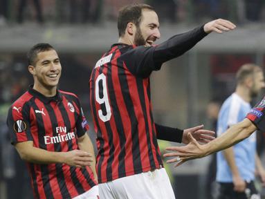 Striker AC Milan, Fabio Borini bersama Gonzalo Higuain, melakukan selebrasi usai membobol gawang F91 Dudelange pada laga Liga Europa di Stadion San Siro, Kamis (29/11). AC Milan menang 5-2 atas F91 Dudelange. (AP/Luca Bruno)