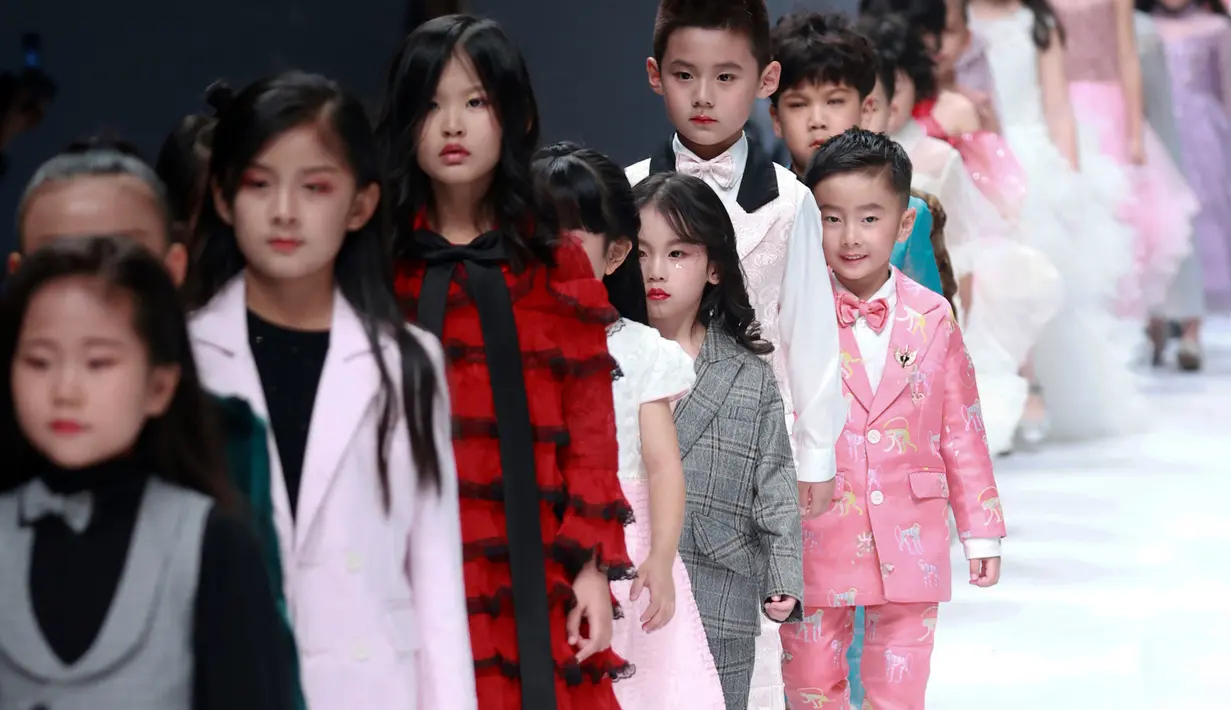 Model anak-anak membawakan busana rancangan KUNJIE oleh Liu Shuming  pada gelaran China Fashion Week di Beijing, China, Selasa (27/10/2020). (STR / AFP)