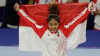Pesenam Indonesia, Rifda Irfanaluthfi, berpose dengan bendera Merah Putih usai pertandingan Senam Artistik SEA Games 2019 di Kompleks Rizal Memorial, Manila, Senin (2/12/2019). Rifda Irfanaluthfi berhasil meraih medali dari nomor all-round individual putri cabang senam. (Bola.com/M Iqbal Ichsan)