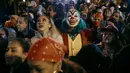 Peserta yang mengenakan kostum Joker berdiri di antara pengunjung saat acara Village Halloween Parade di New York, Amerika Serikat, Selasa (31/10/2023). (AP Photo/Andres Kudacki)