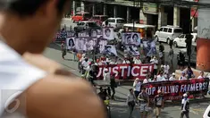 Demonstran menggelar aksi mengecam pembunuhan oleh Tentara Rakyat Baru, Manila, Filipina, Jumat (31/3). Mereka meminta Presiden Duterte untuk membicarakan perdamaian dengan pemberontak agar tidak membunuhi petani. (AP Photo / Aaron Favila)