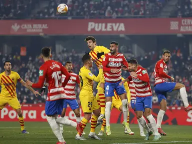 Bek Barcelona Gerard Pique melompat saat berebut bola dengan gelandang Granada Maxime Gonalons dalam jornada ke-20 Liga Spanyol 2021/2022 di Stadion Los Carmenes, Minggu (9/1/2022) dini hari WIB. Barcelona ditahan imbang 1-1 Granada. (AP Photo/Fermin Rodriguez)