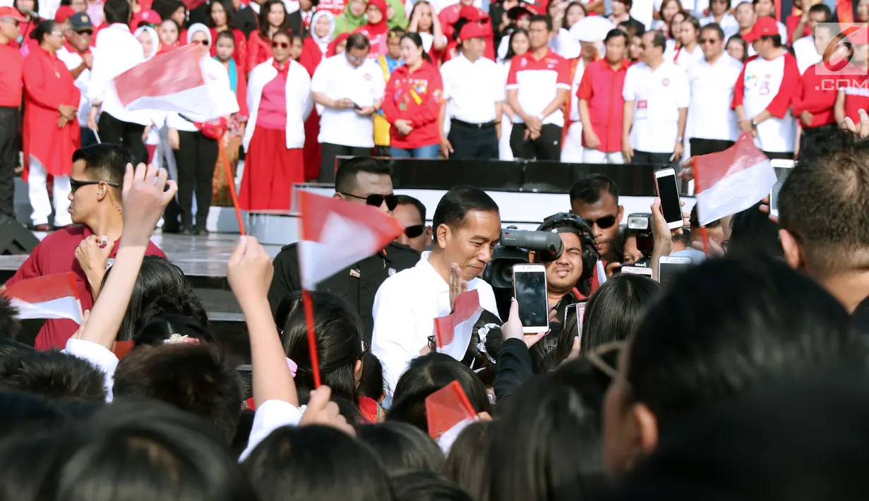 Presiden RI, Joko Widodo (tengah) menyapa peserta Harmoni Indonesia 2018 di Kompleks Gelora Bung Karno, Jakarta, Minggu (5/8). Harmoni Indonesia adalah bernyanyi bersama secara serentak lagu-lagu kebangsaan di 34 kota. (Liputan6.com/Helmi Fithriansyah)