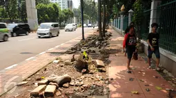 Pengguna jalan melintasi trotoar Jalan Asia Afrika, Jakarta, Selasa (24/5/2016). Pasca pembongkaran lapak pedagang tanaman pekan lalu, sisa pembongkaran masih terlihat dan membuat trotoar terlihat berantakan. (Liputan6.com/Helmi Fithriansyah)