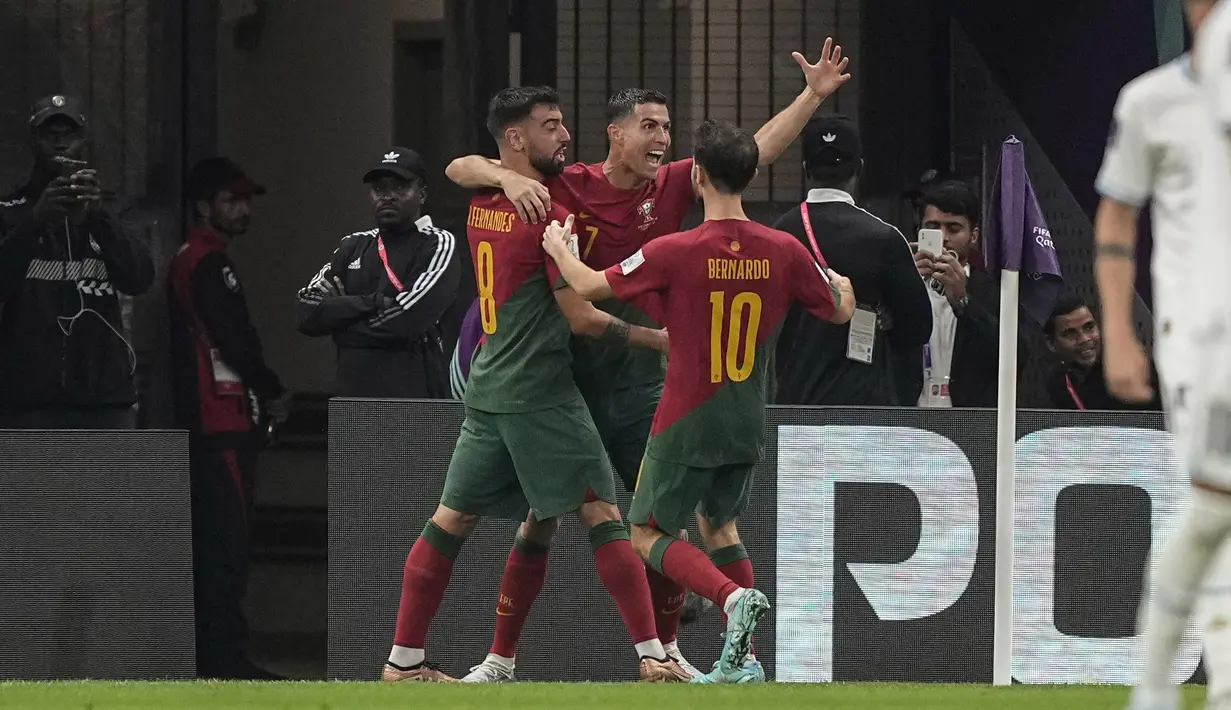 <p>Pemain timnas Portugal, Cristiano Ronaldo memeluk rekan satu timnya, Bruno Fernandes usai menjebol gawang Uruguay dalam pertandingan kedua grup H Piala Dunia 2022 yang berlangsung di Lusail Stadium, Qatar, Selasa (29/11/2022).&nbsp;(AP Photo/Martin Meissner)</p>