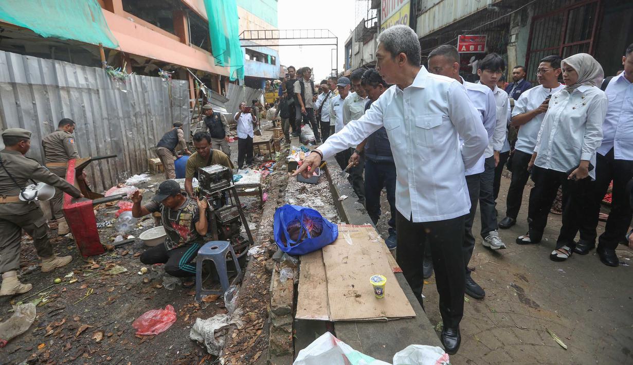 Namun, hingga Rabu 25 Maret 2026, sebagian PKL masih nekat berjualan di lokasi tersebut. Tampak dalam foto, Wali Kota Bogor, Dedie A. Rachim (kanan) saat meninjau penertiban Pedagang Kaki Lima (PKL) di Eks Pasar Bogor, Jawa Barat, Rabu (25/3/2026). (merdeka.com/Arie Basuki)
