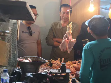 Calon Presiden Nomor Urut 01 Joko Widodo (Jokowi) berdialog dengan pedagang ayam saat blusukan ke Pasar Cihaurgeulis, Bandung, Minggu (11/11). Jokowi berkeliling pasar dan menyapa para penjual juga membeli beberapa bahan pangan (Liputan6.com/Angga Yuniar)