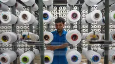 Seorang pekerja mengatur gulungan benang untuk alat tenun di pabrik Trisula Textile Industries di Cimahi, Jawa Barat pada 15 April 2025. (TIMUR MATAHARI/AFP)
