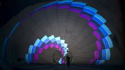Salah seorang peserta sedang mempersiapkan balon udaranya saat Festival Balon Udara Internasional di Taman Nasional Maayan Harod, Israel (30/9/2015). (REUTERS / Baz Ratner)