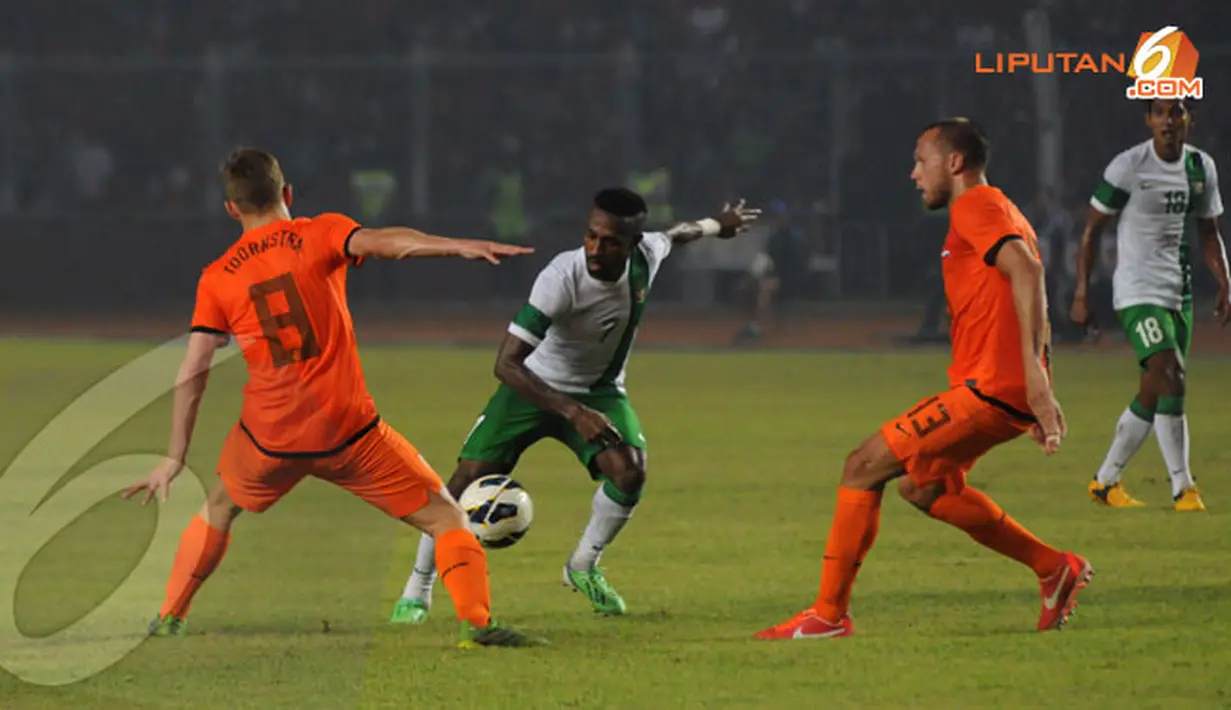 Penyerang Timnas Indonesia (Boaz Salossa) dikawal ketat oleh dua pemain belakang Belanda dalam laga ang dihelat di Stadion GBK pada 7 Juni 2013 (Liputan6.com/Helmi Fithriansyah)