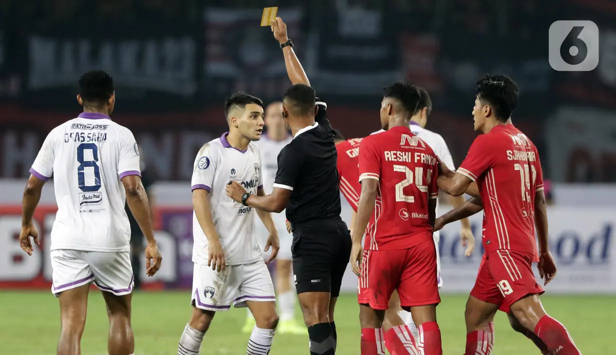 Pemain Persita, Norberto Ezequiel Vidal (kedua kiri) mendapat kartu kuning dari wasit Agus Fauzan Arifin saat melawan Persija pada lanjutan laga BRI Liga 1 Indonesia 2022-2023 di Stadion Patriot Chandrabhaga, Bekasi, Rabu (24/8/2022). Laga berlangsung sengit dan dimenangkan Persija dengan skor 1-0. (Liputan6.com/Helmi Fithriansyah)