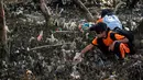 Seorang anak membersihkan sampah pada kegiatan World Cleanup Day 2019  di kawasan pantai di Surabaya, Sabtu (21/9/2019). Aksi bersih-bersih sampah yang digelar secara serentak di 157 negara ini mengajak masyarakat untuk bijak menggunakan plastik.  (JUNI KRISWANTO / AFP)