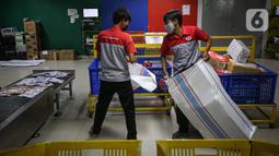 Pekerja memilah paket kiriman barang di Kantor Cabang JNE, Jakarta, Kamis (30/12/2021). Supply Chain Indonesia (SCI) memprediksi peningkatan pengiriman barang pada akhir tahun ini mencapai 20 persen untuk ke wilayah luar Pulau Jawa dan Bali. (Liputan6.com/Faizal Fanani)