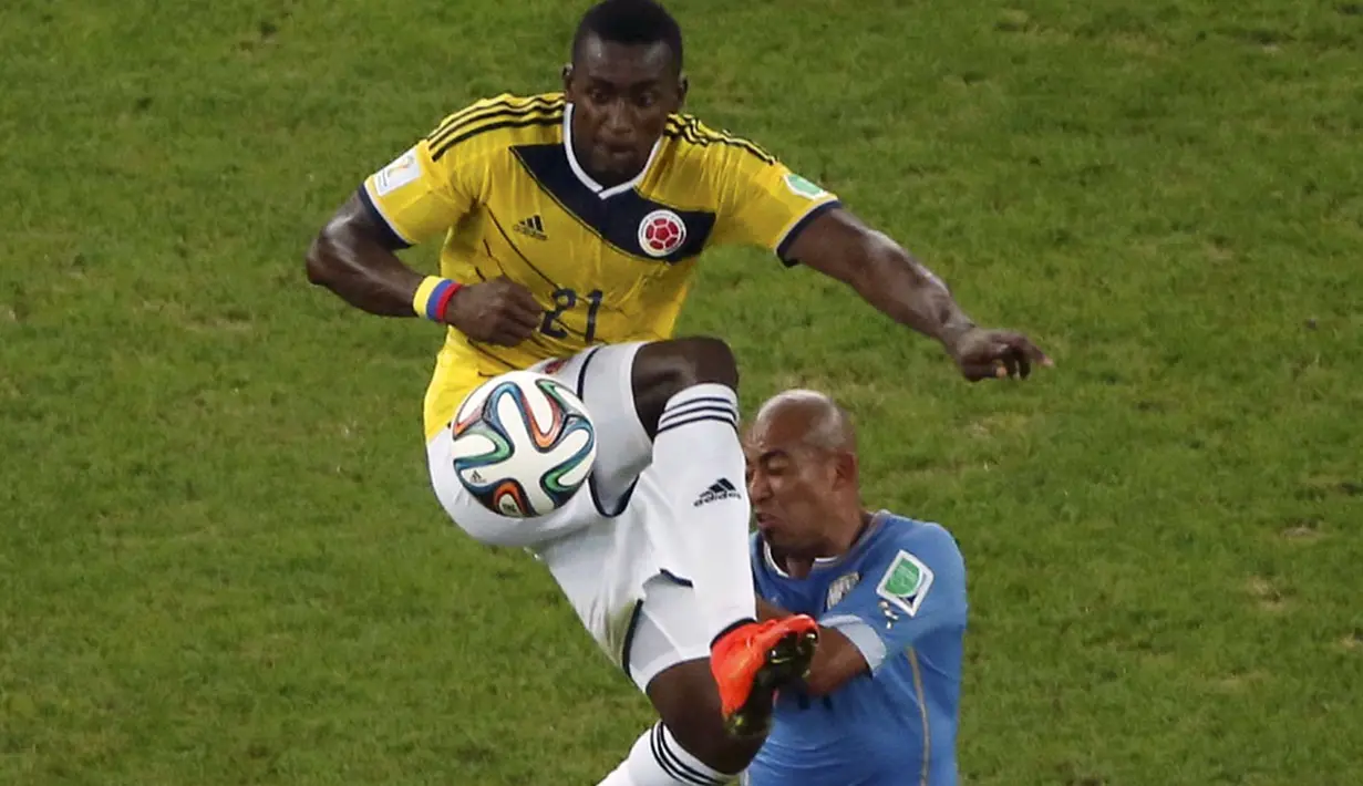 Pemain depan Timnas Kolombia, Jackson Martinez (kiri) meloncat menahan bolba yang mengarah ke Egidio Arevalo Rios (Uruguay), saat berlaga di 16 besar Piala Dunia 2014 di Stadion Maracana, Rio de Janeiro, (29/6/2014). (REUTERS/Fabrizio Bensch)