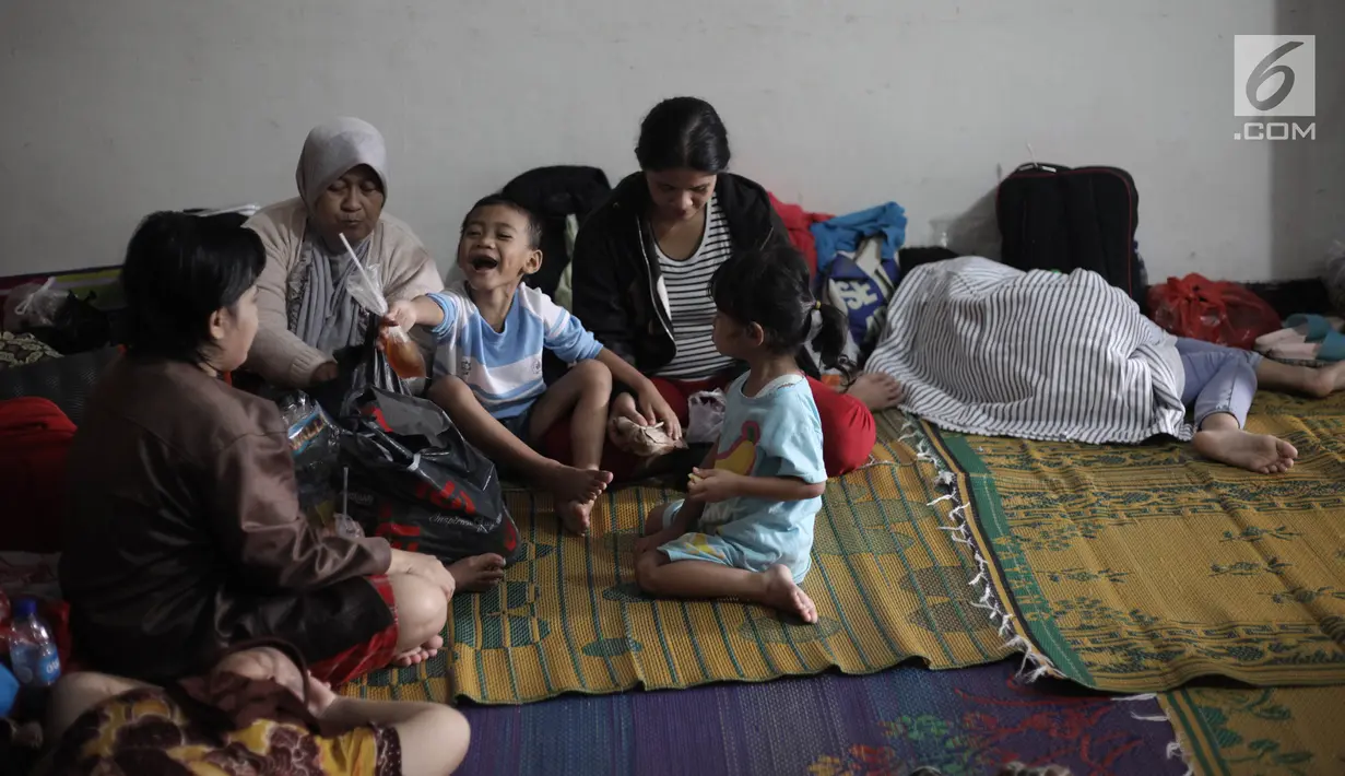 Sejumlah pengungsi banjir melakukan aktivitas saat mengungsi di Kelurahan Kampung Melayu, Jatinegara, Jakarta Timur, Rabu (7/2). Puluhan KK mengungsi di tempat tersebut. (Liputan6.com/Arya Manggala)