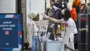 Asisten toko yang mengenakan masker memeriksa suhu tubuh seorang pelanggan di CF Toronto Eaton Center, Toronto, Kanada, 6 Oktober 2020. Jumlah kasus harian COVID-19 di Kanada terus bertambah. (Xinhua/Zou Zheng)