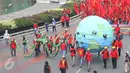 Massa buruh dari KASBI membawa gurita raksasa, bola dunia dan tikus pada peringatan May Day di Bundaran HI, Jakarta, Senin (1/5). Replika gurita itu dianggap simbol penghisap sumber daya alam yang ada di Indonesia. (Liputan6.com/Angga Yuniar)