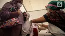 Seorang pelajar didampingi orangtuanya menerima suntikan vaksin covid-19 di Gudang Darurat Nasional Palang Merah Indonesia, Jakarta, Kamis (15/7/2021). Vaksinasi yang menargetkan seribu peserta per hari diselenggarakan hingga 17 Juli 2021. (Liputan6.com/Johan Tallo)