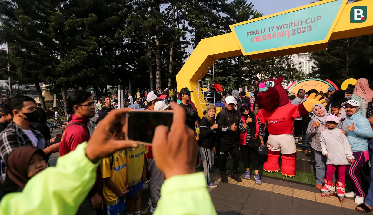 Para pengunjung berfoto bareng dengan maskot Piala Dunia U-17 2023, Bacuya dalam rangkaian acara Trophy Tour Experience menyambut Piala Dunia U-17 di Cikapayang Dago Park, Bandung, Minggu (22/10/2023) pagi WIB. (Bola.com/Bagaskara Lazuardi)