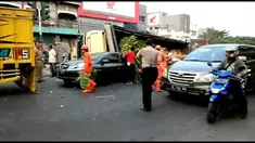 Akibat kelebihan muatan truk pengangkut sayuran terguling dan menimpa sebuah sedan di kawasan Srengseng Jakarta Barat.