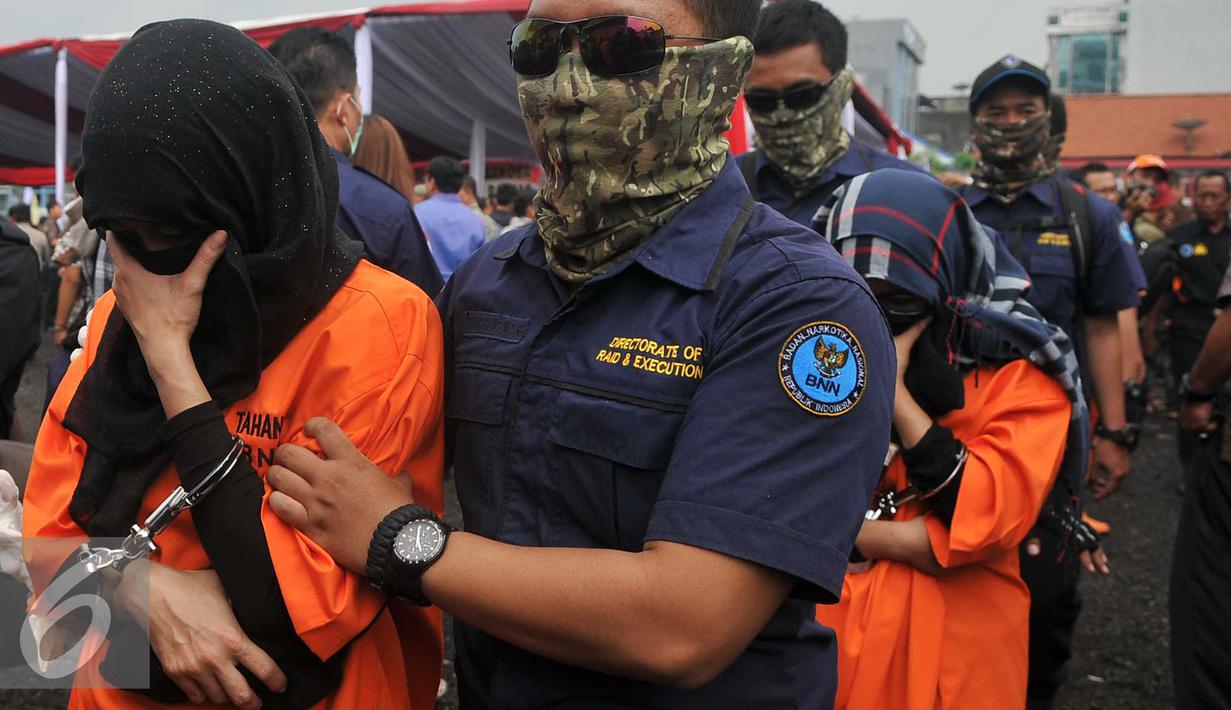 Tersangka saat dikawal petugas saat pemusnahan barang bukti narkotik jenis shabu sebanyak 120 kilogram di Jakarta, Jumat (26/2). Barang bukti narkoba didapat BNN dari hasil tangkapan sejak awal Januari 2016. (Liputan6.com/Gempur M Surya)