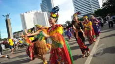 Kelompok seniman T-Ta asal Universitas Paramadina menari saat car free day di Bundara HI, Jakarta, Minggu (26/4/2015). Mereka meminta sumbangan kepada warga untuk mengikuti Interntional Folklore Festival di Spanyol. (Liputan6.com/Faizal Fanani)
