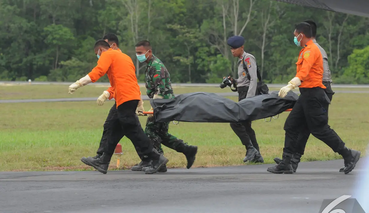  Petugas gabungan memindahkan kantong berisi jenazah penumpang AirAsia QZ8501,   Lanud Iskandar, Pangkalan Bun, Kalteng, Rabu (8/1/2015). (Liputan6.com/Herman   Zakharia)