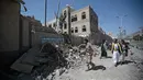 Warga Yaman memeriksa kerusakan yang terjadi akibat serangan udara di kompleks kepresidenan, di Sanaa, Yaman (7/5). Akibat serangan ini sedikitnya enam orang tewas dan sekitar 30 orang terluka. (AP Photo/Hani Mohammed)